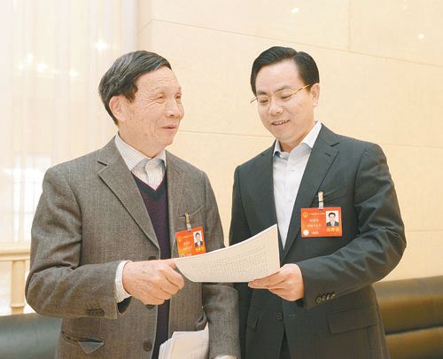 黃伯云代表（左）與劉國(guó)忠代表商討完善《關(guān)于建立戰(zhàn)略性新興產(chǎn)業(yè)國(guó)家創(chuàng)新平臺(tái)》的建議。 本報(bào)記者 張目 攝